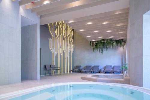 een grote lobby met een hot tub en stoelen bij Nykščio Namai & SPA in Anykščiai