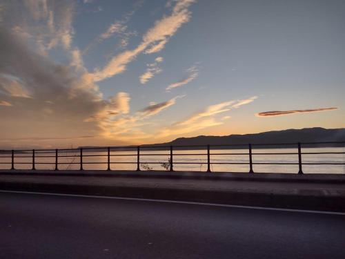 a road with a fence next to a body of water at Casa Azzurra in Messina