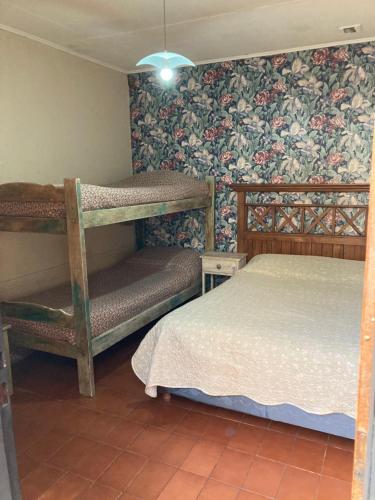 een slaapkamer met 2 stapelbedden en bloemenbehang bij Cirse in Río Gallegos