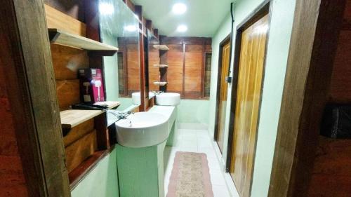 a bathroom with two toilets and a sink at ไชยพล โฮมสเตย์ หมู่บ้านแม่กำปอง in Ban Pok Nai