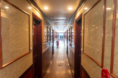 un couloir dans un bâtiment avec une personne au loin dans l'établissement Swan Cruises Halong, à Hạ Long