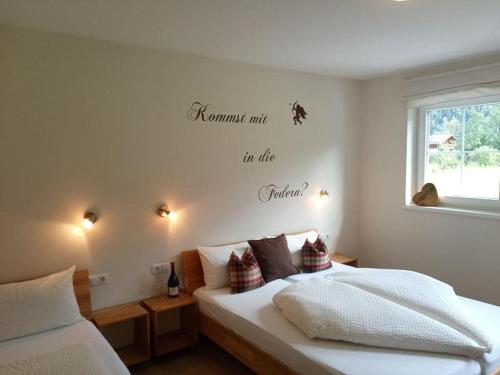 a bedroom with a bed with words on the wall at Landhaus Sporer in Aschau