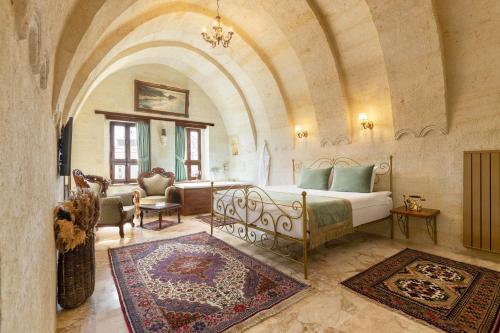 een slaapkamer met een bed en een woonkamer met een bank bij House 1938 Special Cave Hotel in Ortahisar