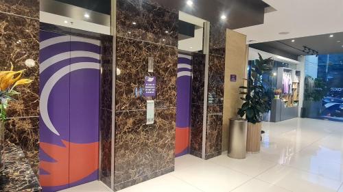 a lobby with elevators in a building at FOX Lite Grogol Jakarta in Jakarta