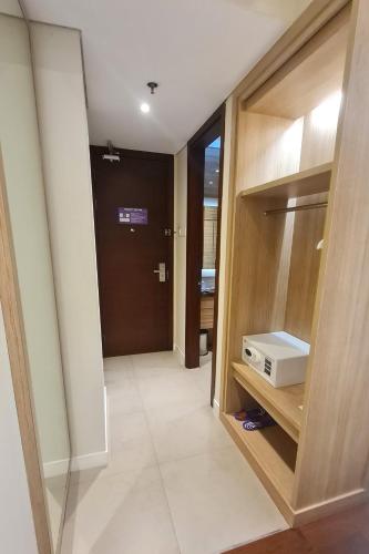 a hallway with a door to a room with a microwave at FOX Lite Grogol Jakarta in Jakarta