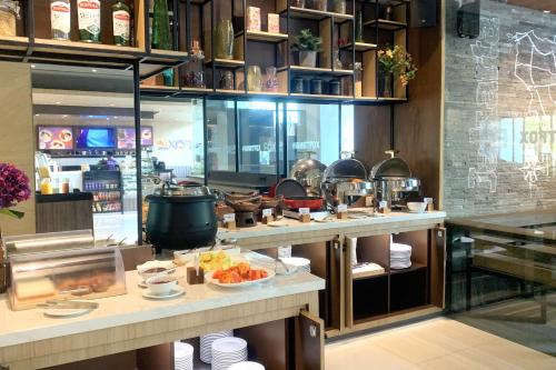 a restaurant with a buffet of food on a counter at FOX Lite Grogol Jakarta in Jakarta
