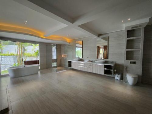 a large bathroom with two sinks and a bath tub at Villa Tamaro Bali in Ubud