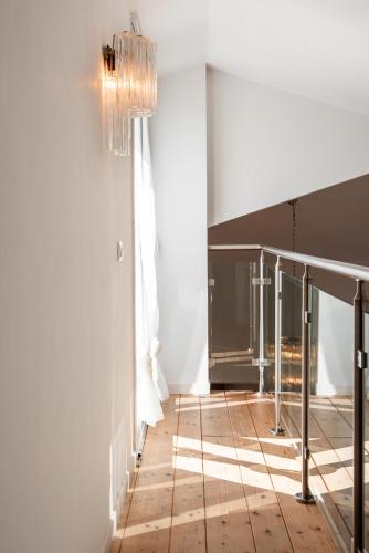 a hallway with a chandelier and a wooden floor at La Casa di Gabri in Málchina