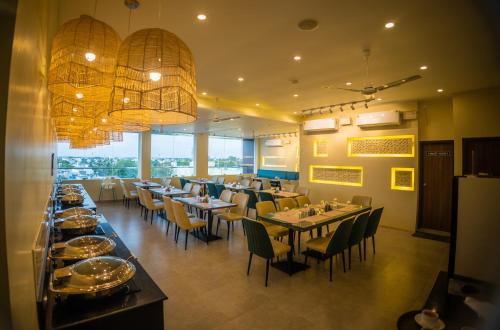 a dining room with tables and chairs and a restaurant at CORAL RESIDENCY in Rāmanāthapuram