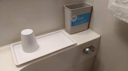 a toilet with a roll of toilet paper on top of it at Toyoko Inn Tokyo Shinjuku gyoemmae eki 3 ban Deguchi in Tokyo