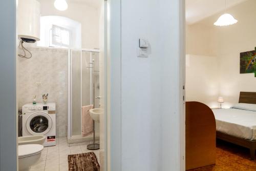 bagno con servizi igienici, lavandino e lavatrice. di Casa la Fortezza a Porto Santo Stefano