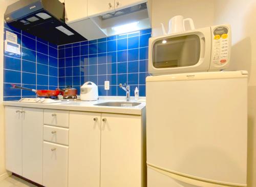 a kitchen with a refrigerator and a tv on top of it at Pangoo Shinagawa in Tokyo