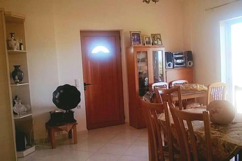 a dining room with a table and a red door at Μεζονέτα 5 υπνοδωμάτια, πλήρως εξοπλισμένη και με φορτιστή ηλεκτρικού αυτοκινήτου in Arfará