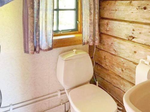 baño con aseo y lavabo y ventana en Holiday home Bryggja II, en Bryggja