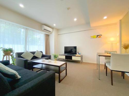 a living room with a couch and a tv at Pangoo Shinagawa in Tokyo