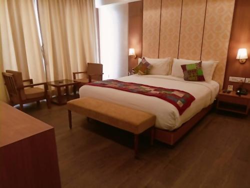 a hotel room with a large bed and a table at Abhyagama Hotel in Digha