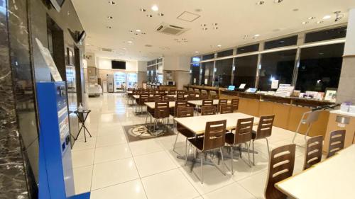 a restaurant with rows of tables and chairs at Toyoko Inn Okayama eki Nishi guchi Hiroba in Okayama