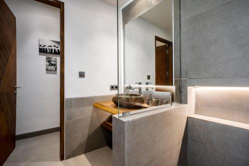 ein Bad mit einem Waschbecken und einem Spiegel in der Unterkunft Villa Oasis by BaliSuperHost in Ubud
