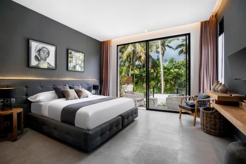 ein Schlafzimmer mit einem großen Bett und einem großen Fenster in der Unterkunft Villa Oasis by BaliSuperHost in Ubud