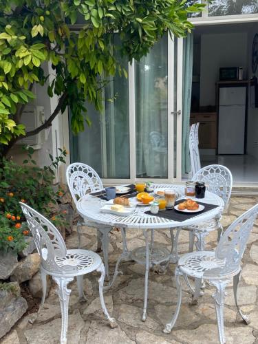 une table et des chaises blanches avec de la nourriture dans l'établissement Le p'tit mandarinier, à Canet d'Aude