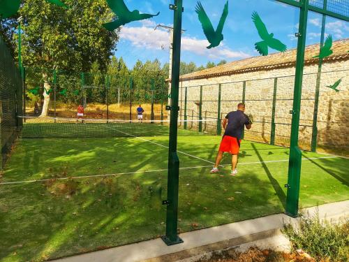 a man is playing tennis on a tennis court at Hotel SPA El Lagar de Isilla in La Vid y Barrios