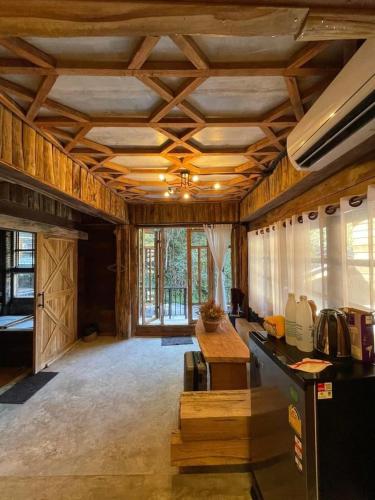 a large room with a kitchen with wooden ceilings at ไชยพล โฮมสเตย์ หมู่บ้านแม่กำปอง in Ban Pok Nai