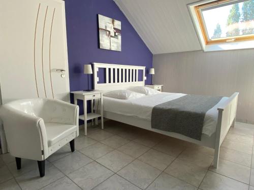 a bedroom with a bed and a chair and a window at Chambre d'hôtes LA COLOMBE in Xouaxange