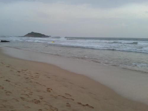 a beach with footprints in the sand and the ocean at Mirissa Cocoon in Mirissa