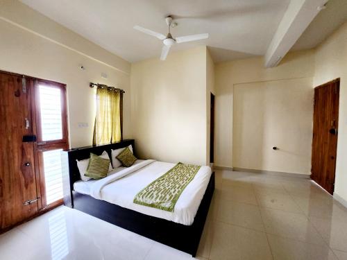 1 dormitorio con cama y ventana en Lishan Apartment, en Mysore
