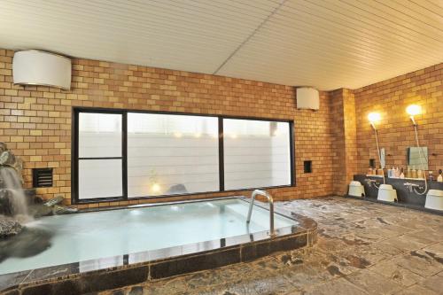ein großer Swimmingpool in einem Raum mit einem großen Fenster in der Unterkunft The Gran Resort Elegante Karuizawa in Karuizawa