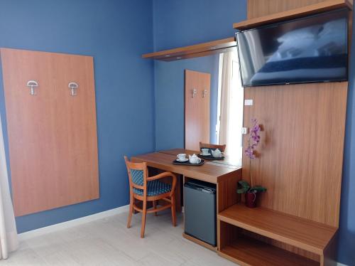 a room with a desk and a tv in a room at Hotel Verona in Caorle