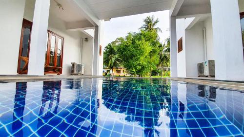 a swimming pool in the middle of a house at Baan Bhuwann Holiday Apartment in Chaloklum