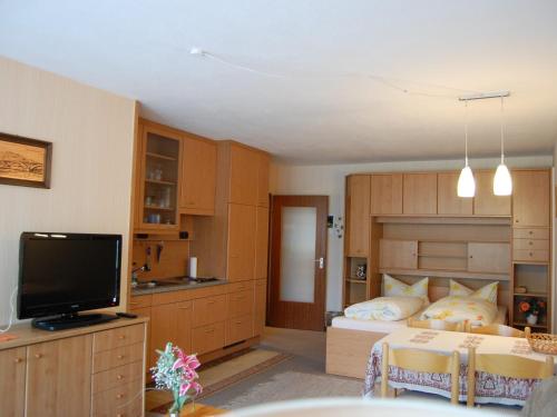 a bedroom with a bed and a flat screen tv at Gasthaus Rehwinkel in Titisee-Neustadt