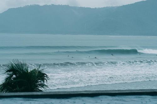 a group of surfers riding a wave in the ocean at Bay's Inn Resort in Baler
