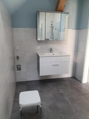 a bathroom with a sink and a stool and a mirror at Urlaubshof Turmblick in Kreba