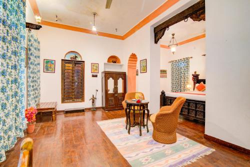 a room with a bed and a table and chairs at Fort Dadhikar, Alwar in Alwar