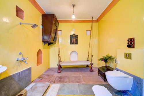a bathroom with a swing bed and a toilet at Fort Dadhikar, Alwar in Alwar