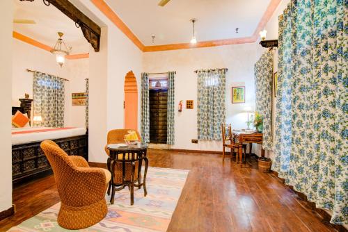 a living room with a table and chairs at Fort Dadhikar, Alwar in Alwar