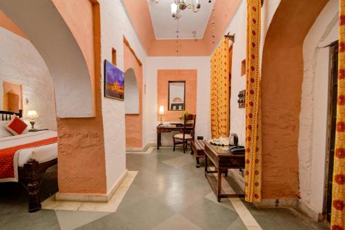 a hotel room with a bed and a table at Fort Dadhikar, Alwar in Alwar
