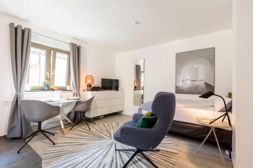 um quarto com uma cama, uma secretária e cadeiras em Appartement Champagne em Neuenstadt am Kocher