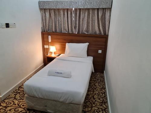 a small bedroom with a white bed with a window at AL KARNAK HOTEL - BRANCH in Dubai