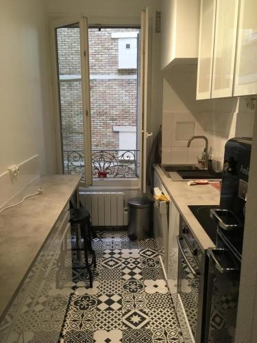 una cucina con pavimento piastrellato in bianco e nero di Alex Flats a Parigi