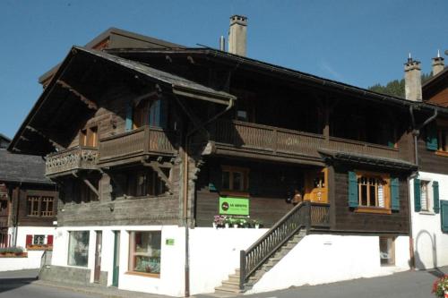 een groot houten gebouw met een balkon aan een straat bij Chalet la Griotte in Villars-sur-Ollon