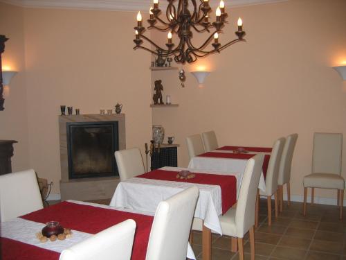 une salle à manger avec deux tables et un lustre dans l'établissement Gästehaus Oswald, à Forst