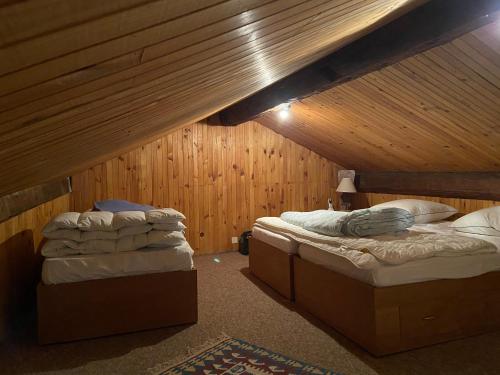 2 Betten in einem Zimmer mit Holzwänden in der Unterkunft Ma petite école in Saint-Martin-de-Belleville
