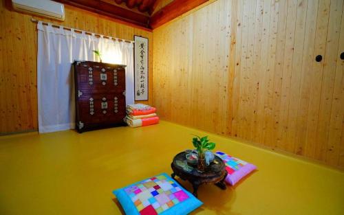 a room with a table and a plant on the floor at Full of Love Guesthouse in Jeonju