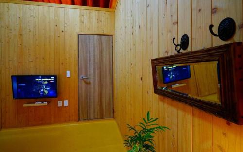 a bathroom with a mirror and a tv and a tub at Full of Love Guesthouse in Jeonju