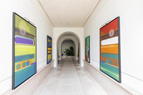 a hallway with colorful paintings on the walls at Grand Hotel Duchi d'Aosta Apartments in Trieste