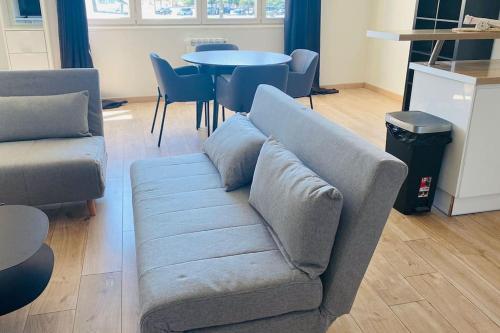 ein Sofa im Wohnzimmer mit einem Tisch in der Unterkunft Montpellier Antigone : Studio récent 4 personnes in Montpellier
