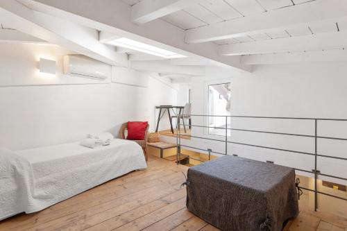 a white room with two beds and a chair at Casa Carla in Lerici